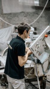 Pracownik obsługujący maszynę w zakładzie produkcyjnym