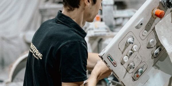 Pracownik obsługujący maszynę w zakładzie produkcyjnym