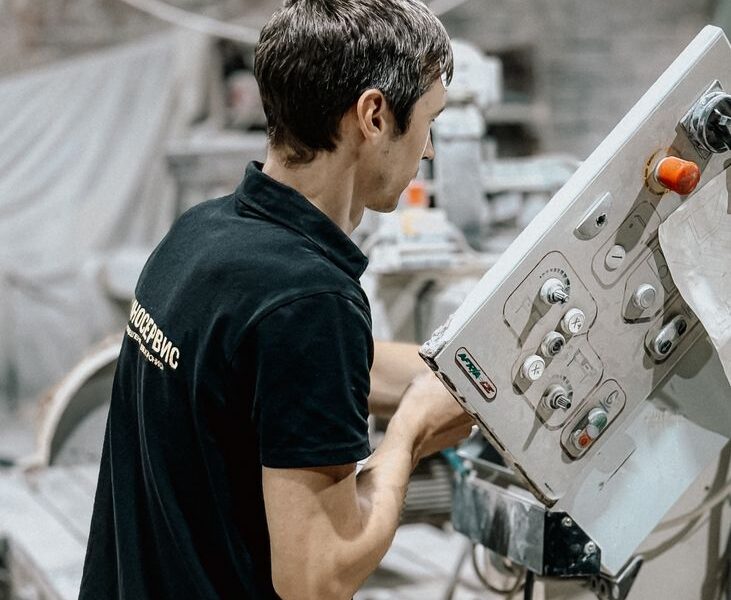 Pracownik obsługujący maszynę w zakładzie produkcyjnym